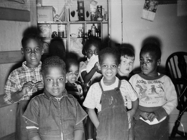 Eight children between the ages of 4 and 7 smile into the camera. Seven of the eight are African-American, and none appear to have any developmental disabilities.